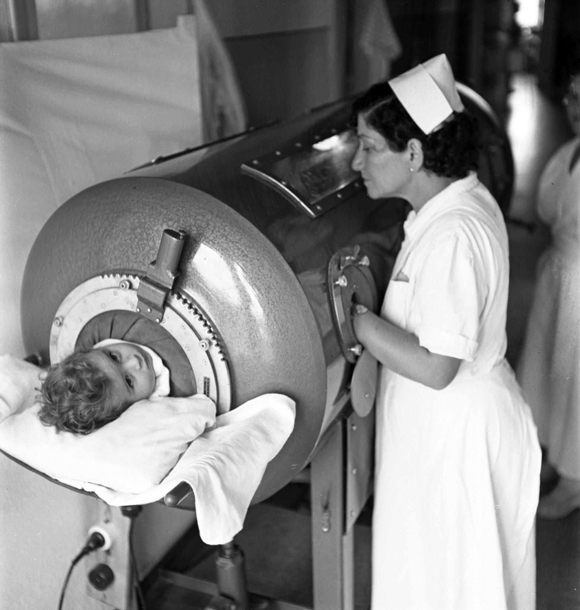 Polio-Ironlung-Unknown Nurse attending to child in an iron lung