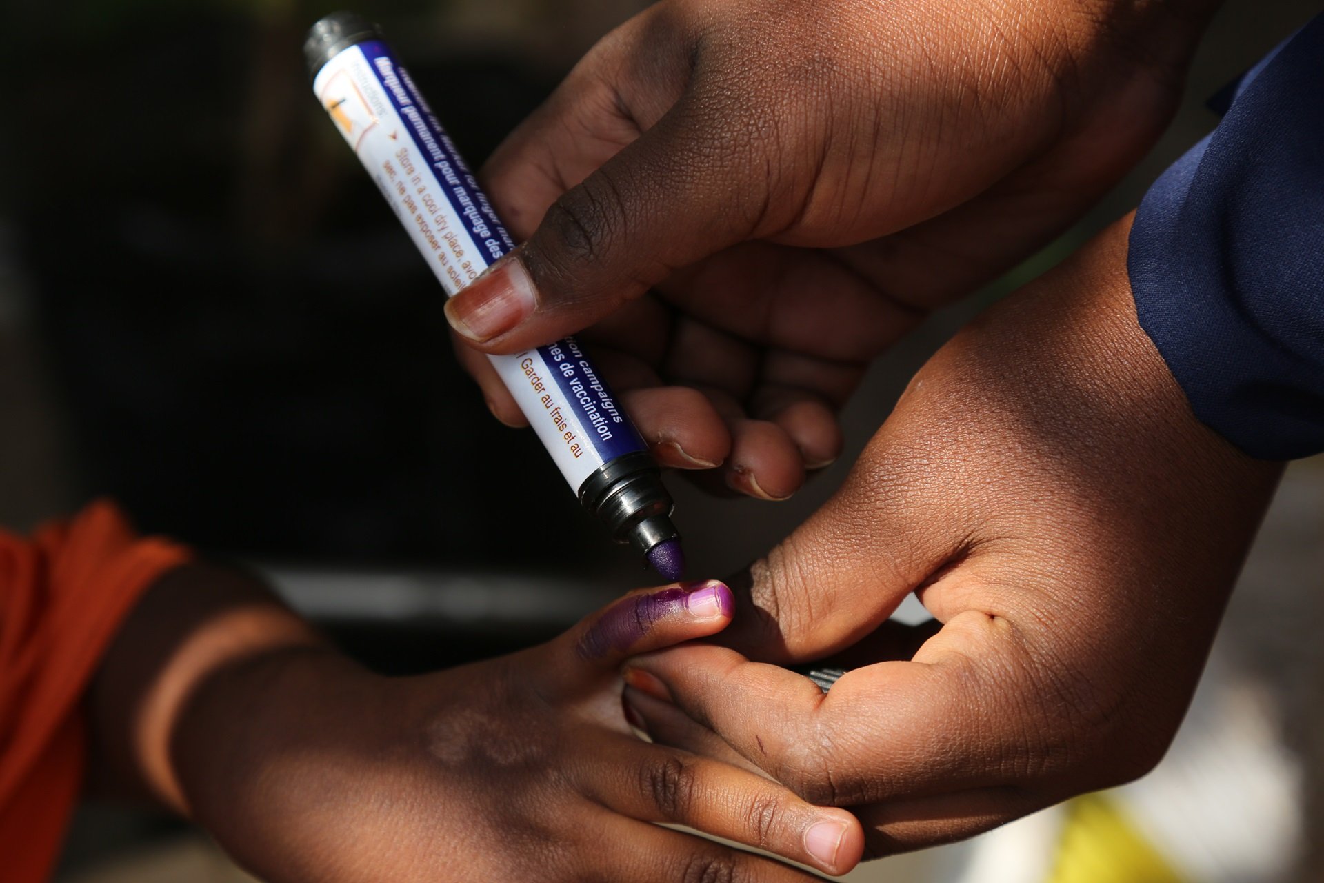 Polio-Unknown-Somalia Health worker marking the finger of a child after vaccination