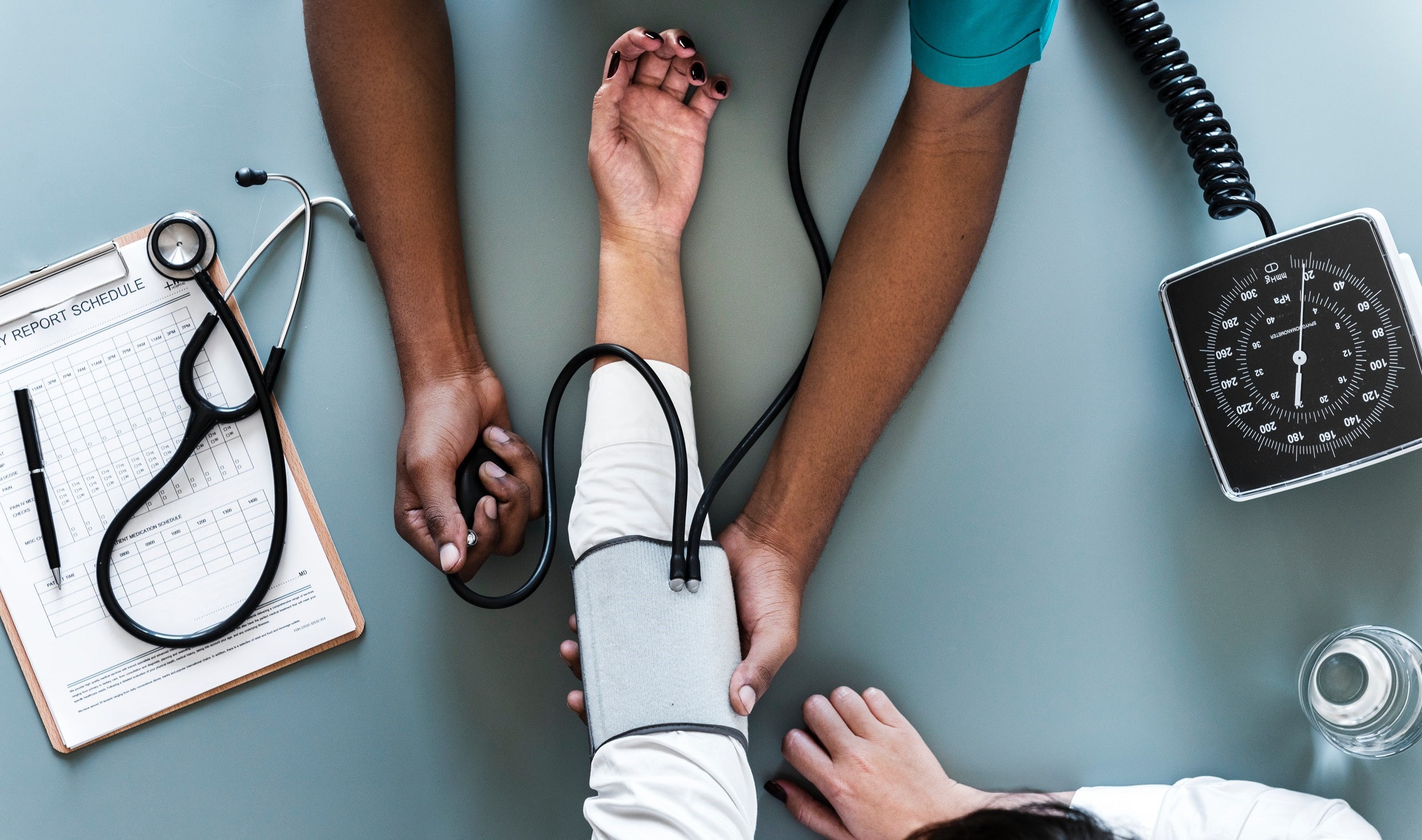A person is having their blood pressure taken by a medical professional