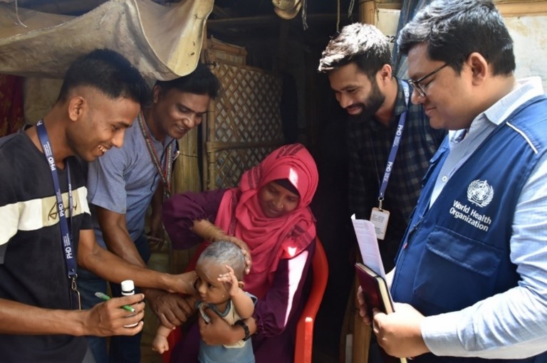 Rohingya child receives a gentle application of Permethrin 1% by WHO staff