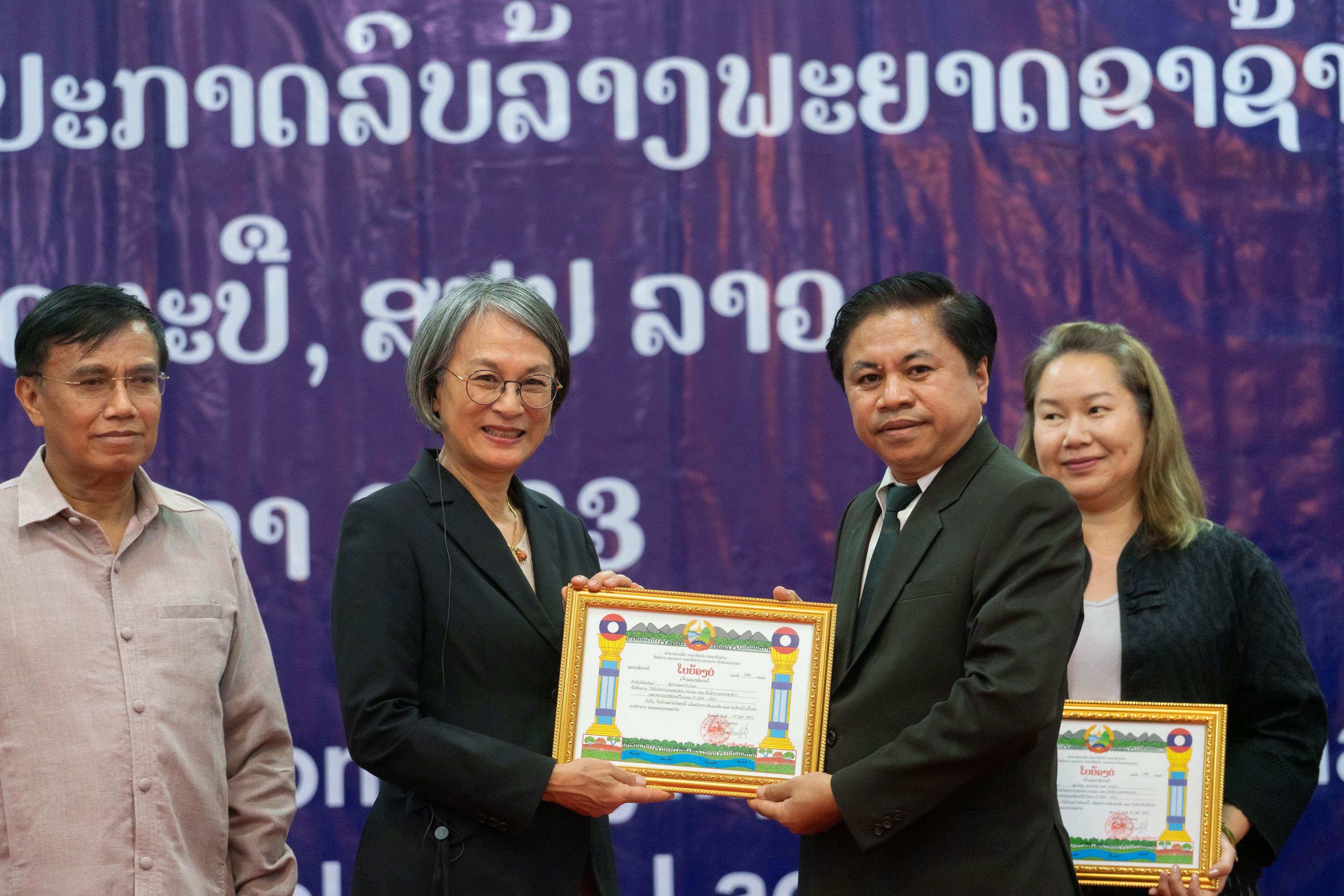 WHO Representative Dr Ying-Ru Lo receiving a certificate of appreciation from Vice Governor of Attapeu MR Bounserth Setthilad