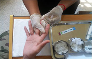 Perform a finger stick for HIV rapid test in Cambodia, KHANA